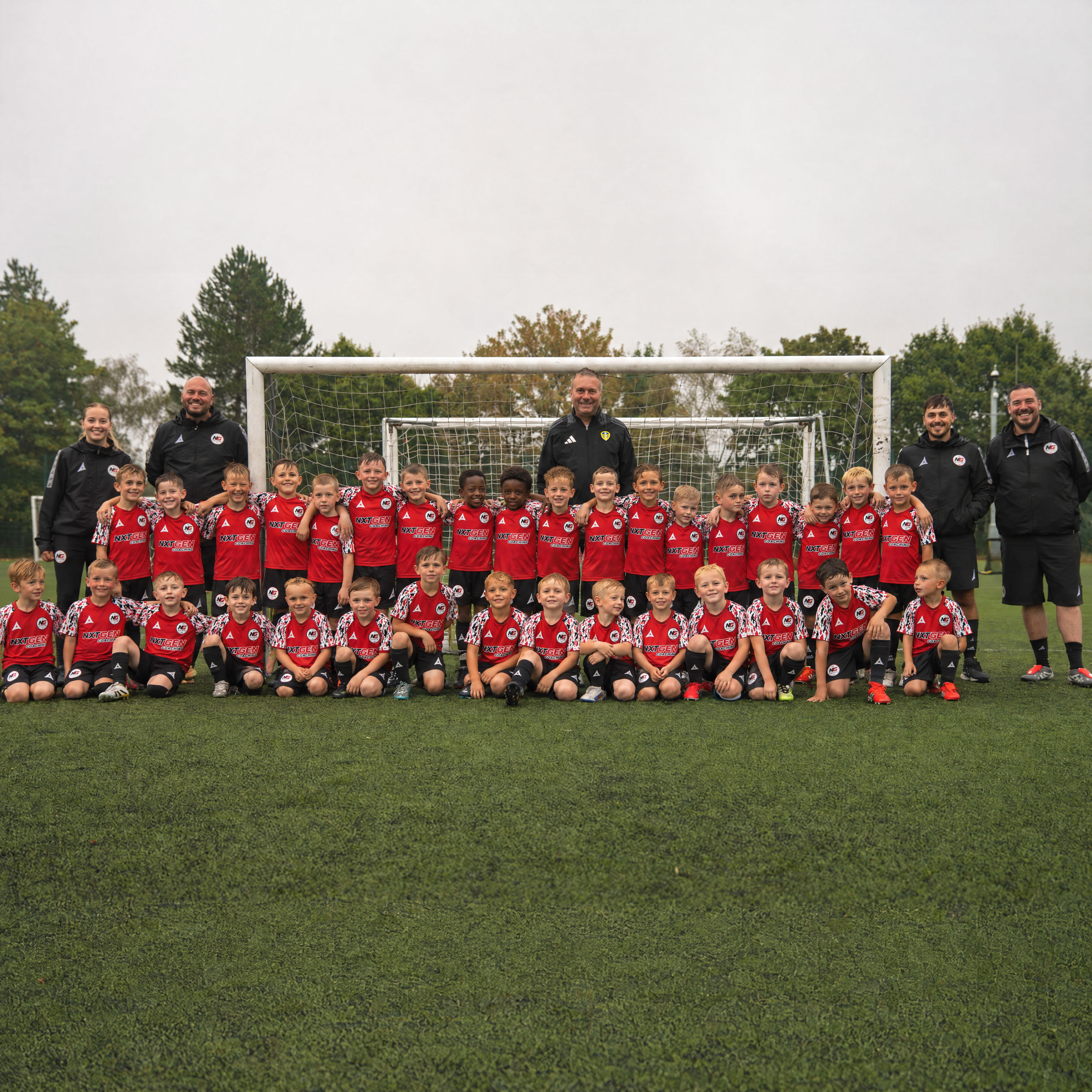 Young footballers training with NXTGEN under floodlights